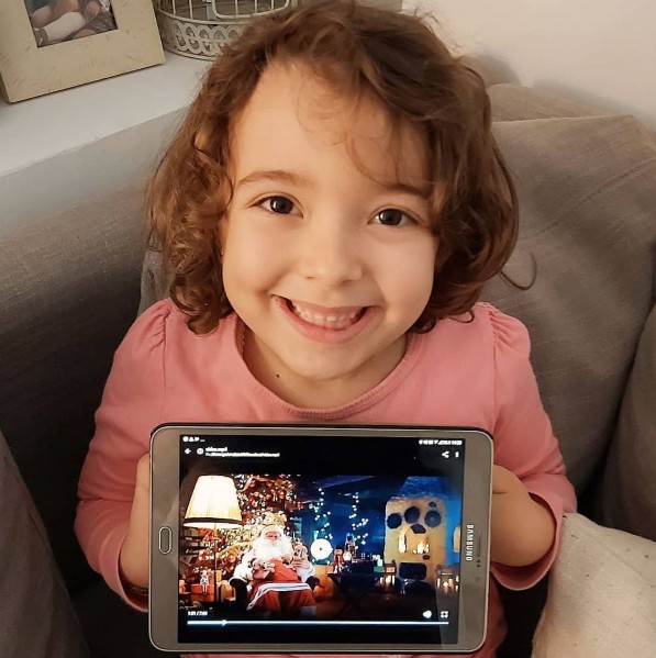 Menina assistindo vídeo personalizado do Papai Noel